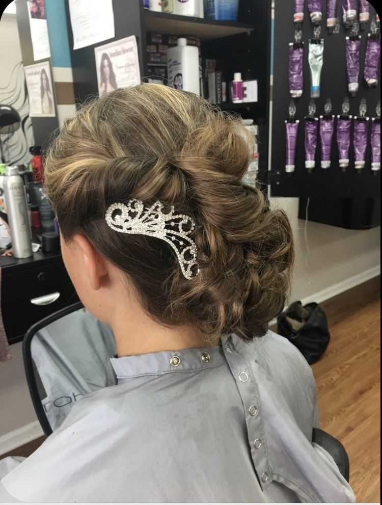 Updo hairstyle with a silver hair clip, viewed from behind in a salon chair.