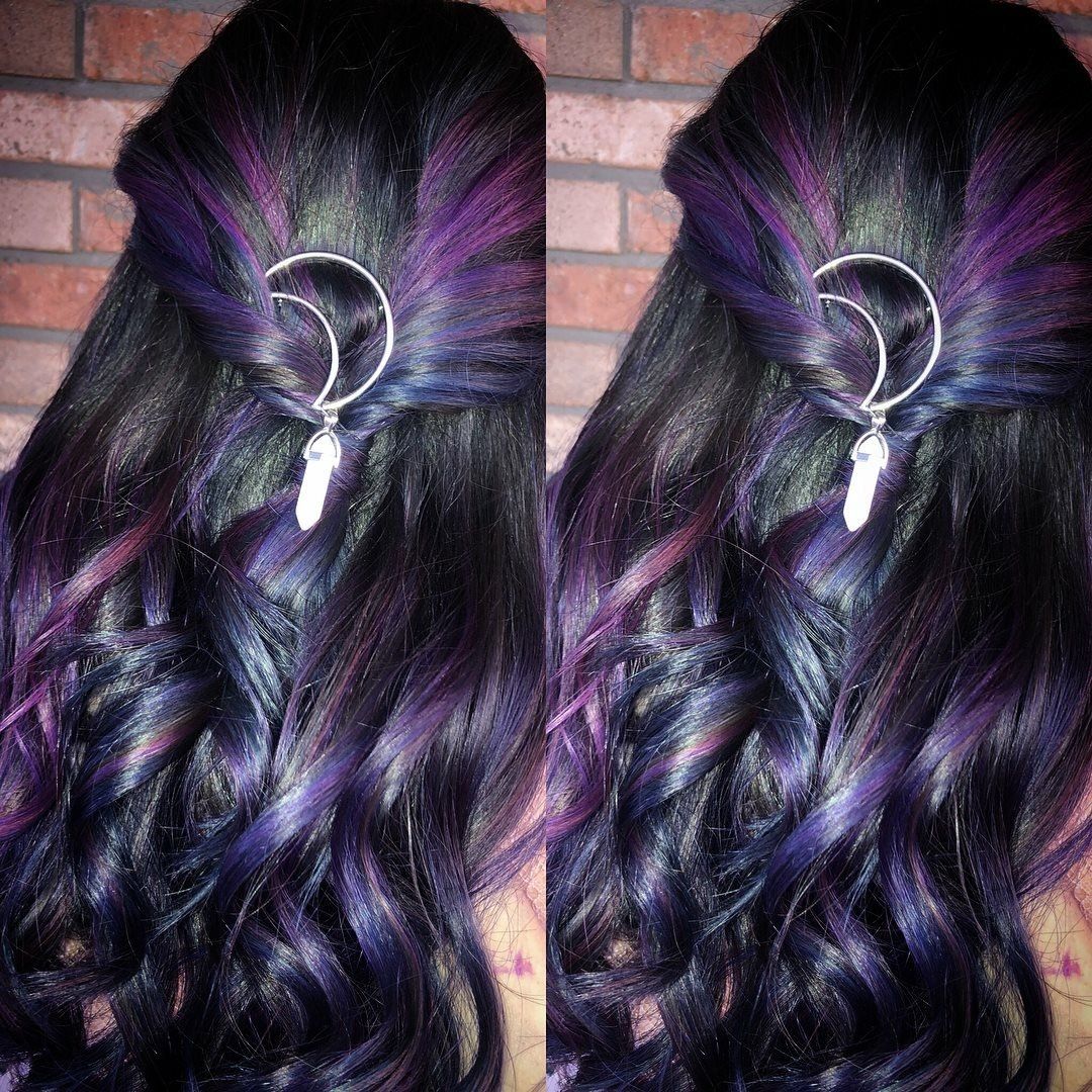 Two braided black and purple hairstyles with silver hoop hair accessories against a brick wall
