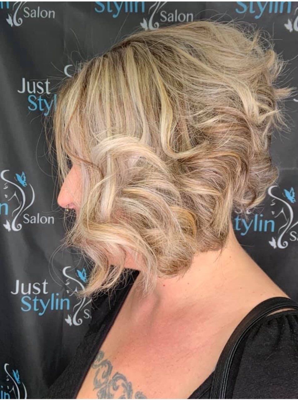 Short blonde wavy bob haircut against a salon backdrop