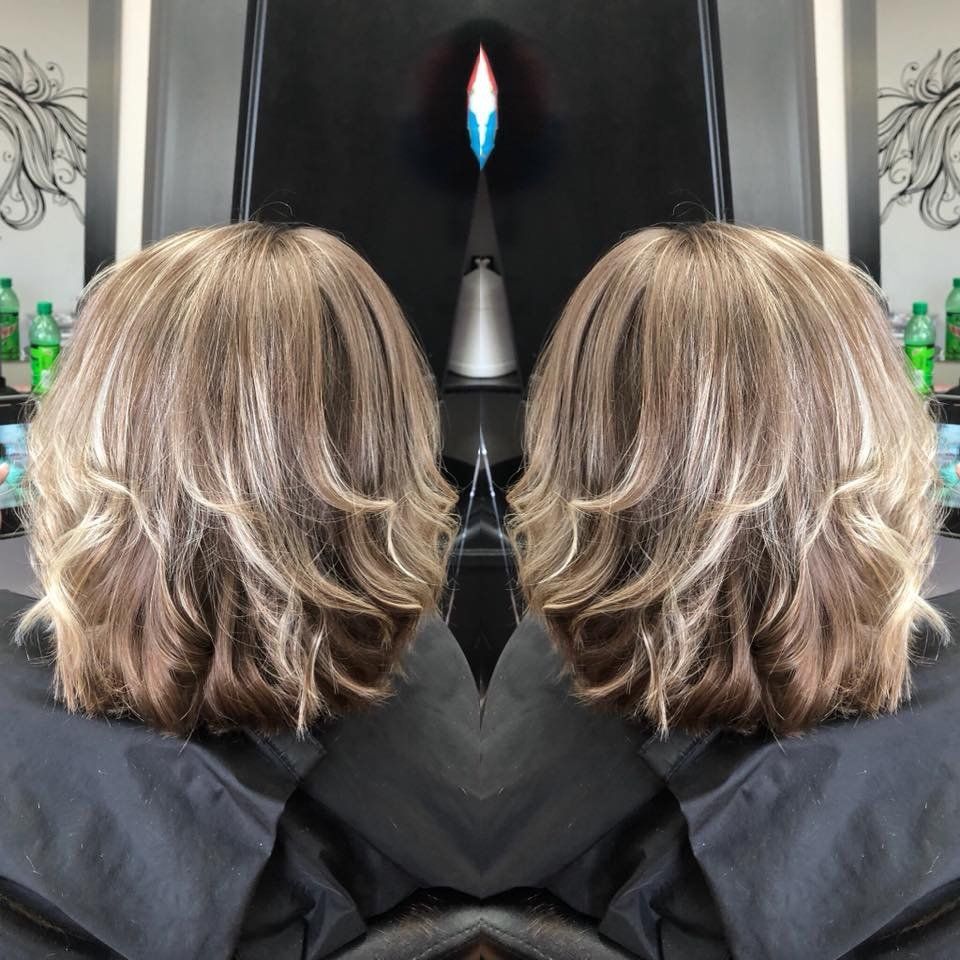 Mirrored photo of a layered blonde-brown bob haircut from the back in a salon chair