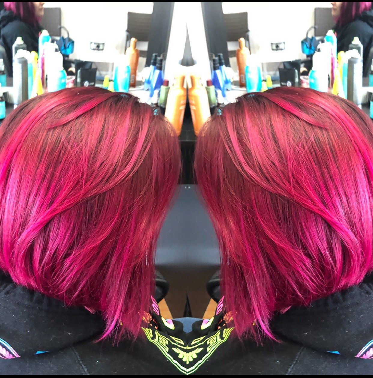 Side-by-side mirrored photos of a person with bright pink bobbed hair in a salon chair