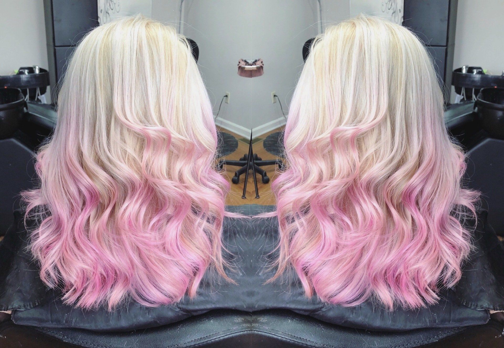 Blonde-to-pink wavy hair shown from the back in a mirrored salon-style photo