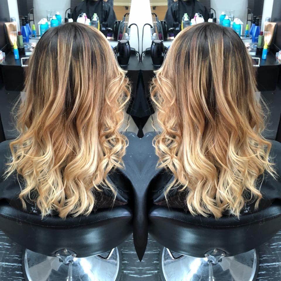 Two mirrored views of long wavy blonde hair in a salon chair